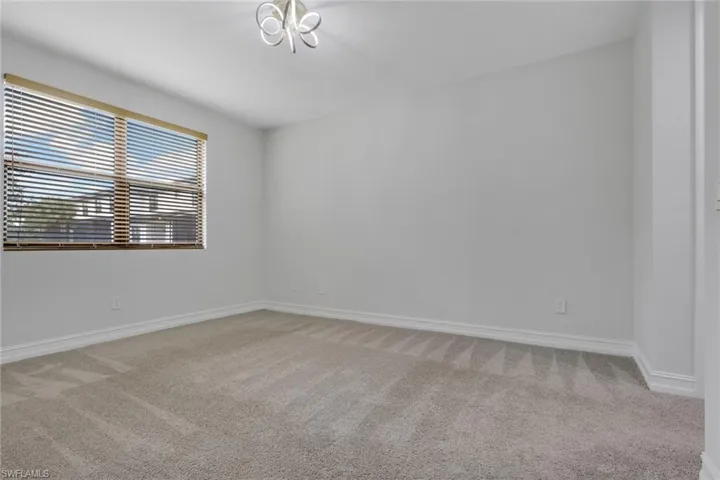 Spare room featuring light carpet and baseboards