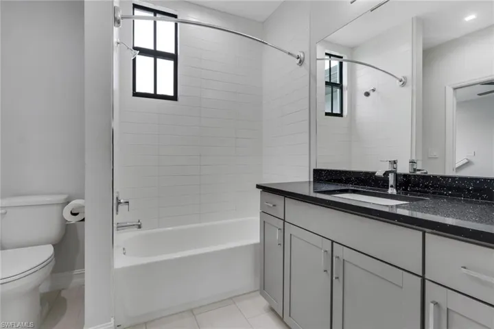 Bathroom featuring vanity, shower / bathtub combination, and light tile patterned floors
