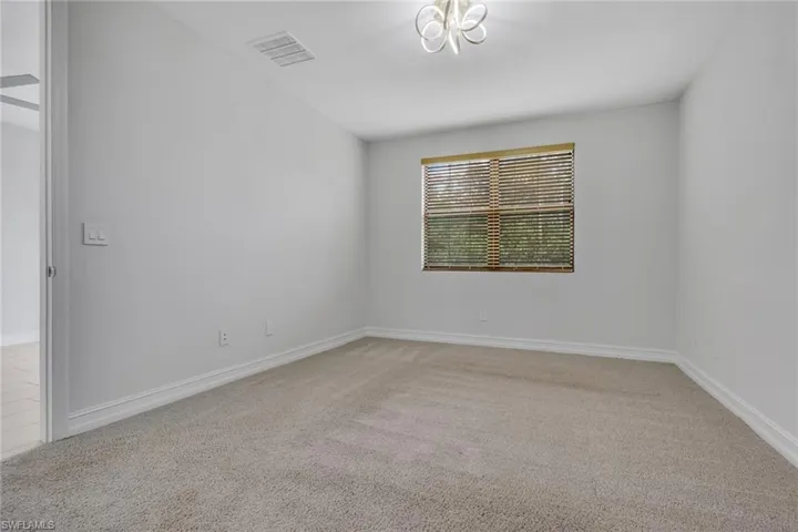 Spare room with light carpet and baseboards