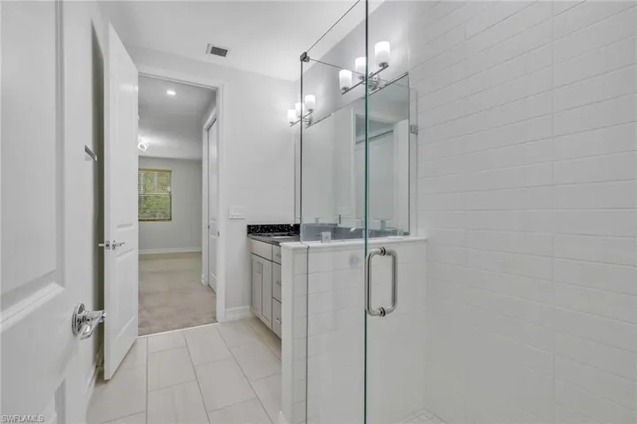 Bathroom with vanity, light tile patterned floors, a stall shower, light colored carpet, and recessed lighting