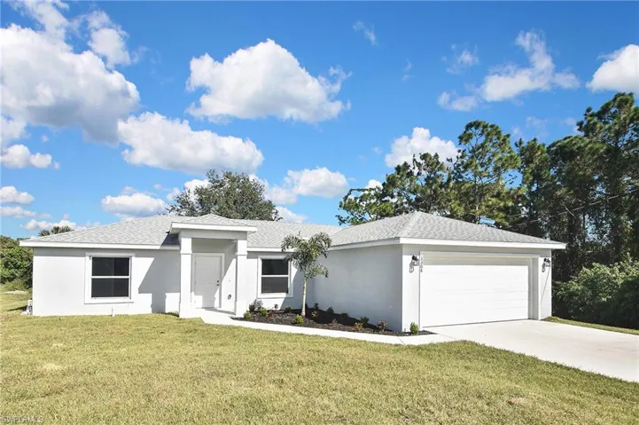 Single story home with a front yard, stucco siding, an attached garage, driveway, and roof with shingles