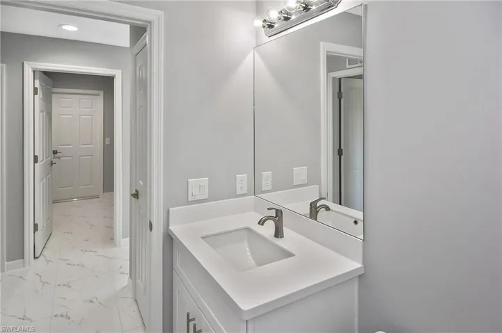 Bathroom featuring light marble finish floors and vanity