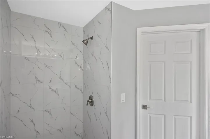 Bathroom featuring a marble finish shower