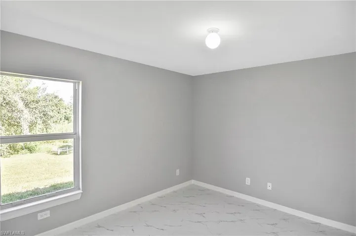 Unfurnished room with baseboards and light marble finish flooring
