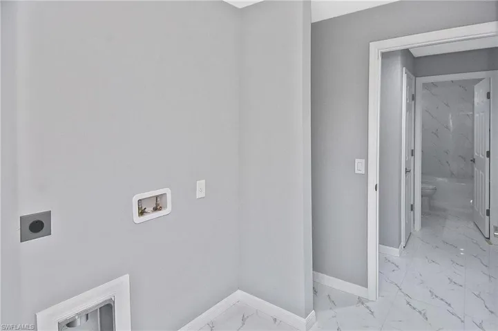 Laundry room with light marble finish flooring, washer hookup, and hookup for an electric dryer