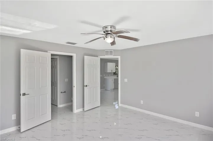 Unfurnished bedroom featuring light marble finish flooring and ceiling fan
