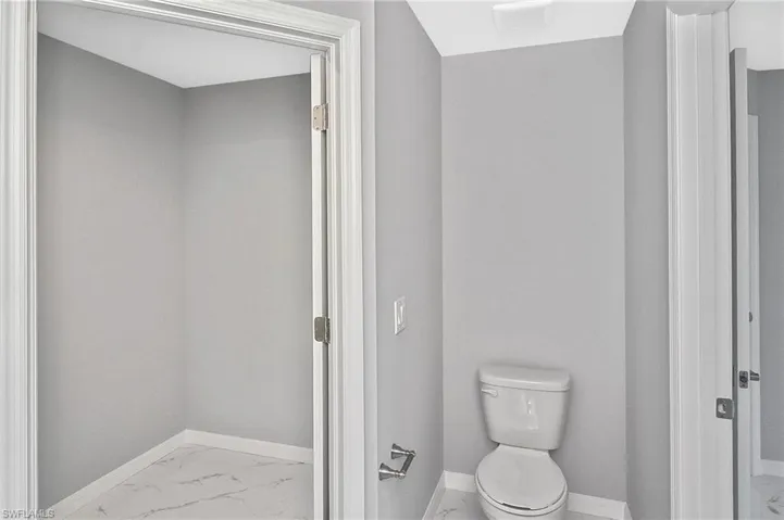 Bathroom featuring baseboards and marble finish flooring