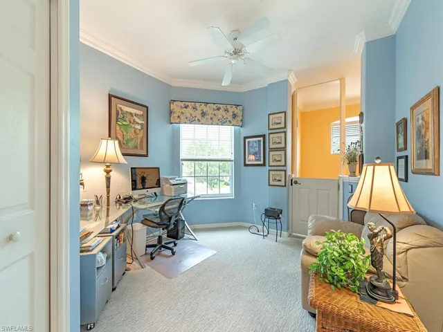 Office area with ornamental molding, light carpet, and ceiling fan