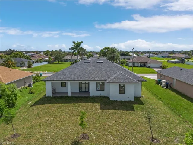 Rear view of property with a lawn
