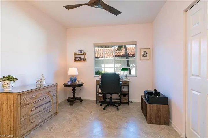 Office with a ceiling fan and baseboards