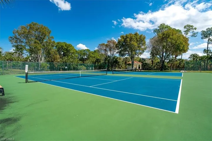 View of tennis court with view of scattered trees
