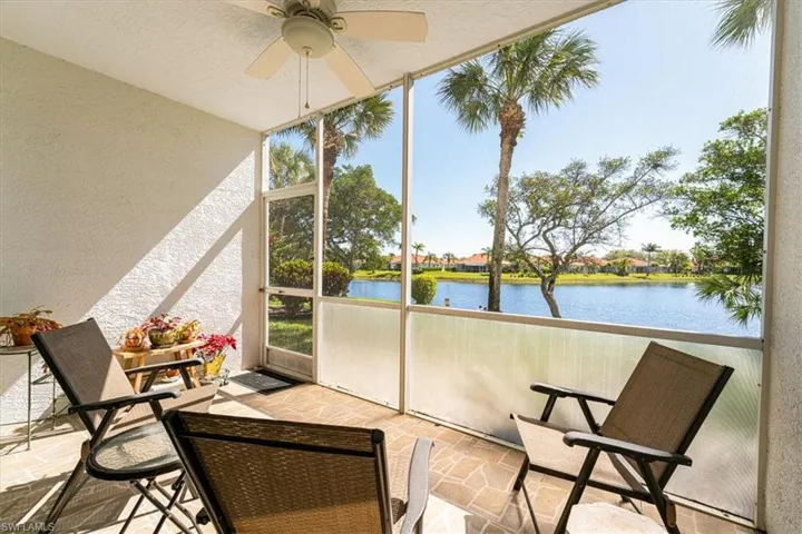 Sunroom / solarium with ceiling fan and a water view