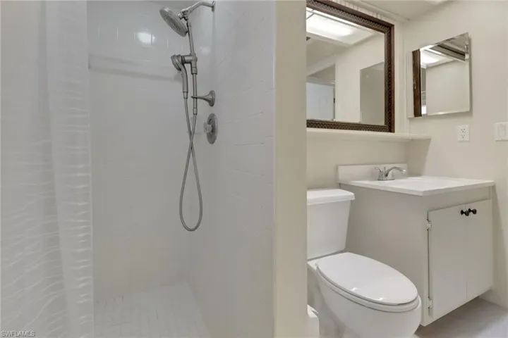 Full bath featuring tiled shower, vanity, and toilet
