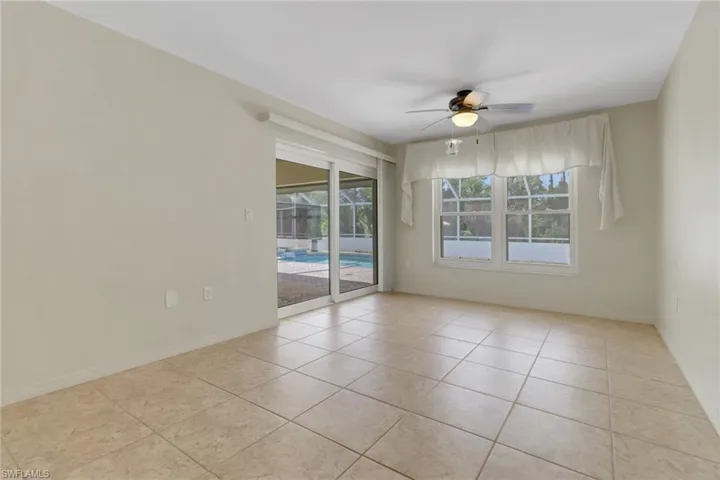 Tiled empty room with baseboards and a ceiling fan