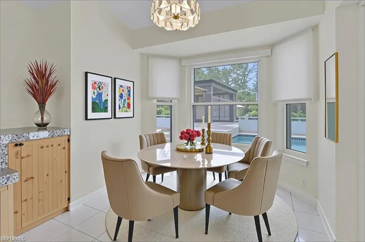 Dining space with light tile patterned flooring and a chandelier