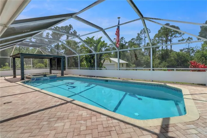 View of swimming pool with a patio area, a pool with connected hot tub, and a lanai