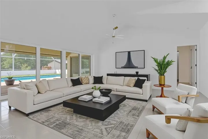 Living area with a ceiling fan, light tile patterned floors, and lofted ceiling
