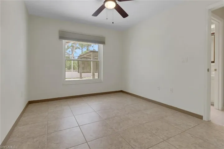 Unfurnished room with light tile patterned floors, baseboards, and a ceiling fan