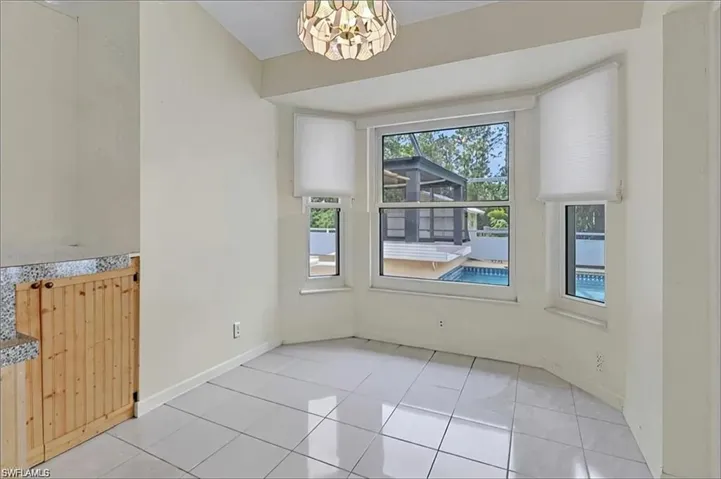 Unfurnished dining area with a chandelier and tile patterned flooring