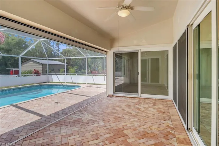 View of pool with a patio area, ceiling fan, a fenced in pool, and a lanai