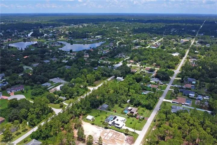 Aerial view of property and surrounding area with a large body of water and nearby suburban area