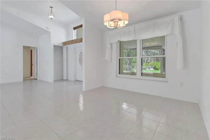 Unfurnished room featuring an inviting chandelier and light tile patterned flooring