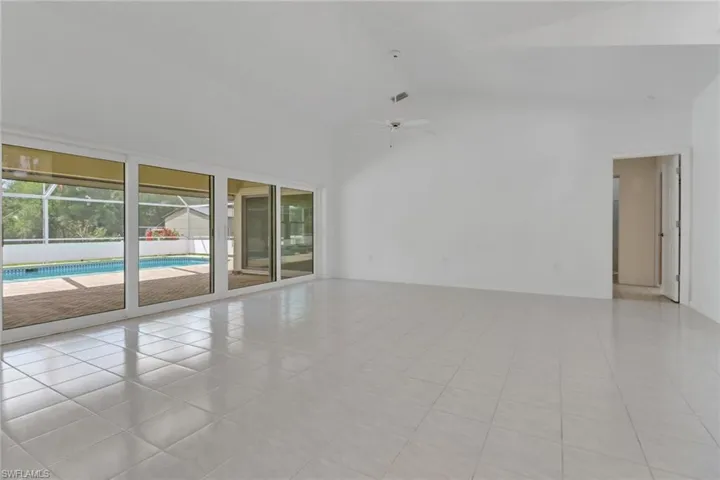 Spare room featuring high vaulted ceiling, ceiling fan, and light tile patterned floors