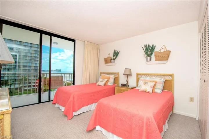 Bedroom featuring a closet, carpet, a textured ceiling, and access to exterior
