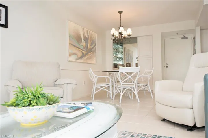 Living room featuring light tile patterned flooring and a notable chandelier