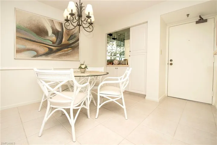 Dining space with a notable chandelier and light tile patterned floors