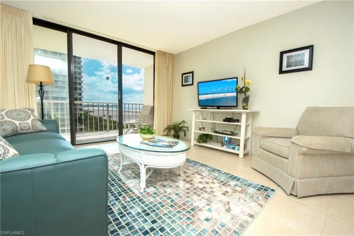 Tiled living room featuring a wall of windows