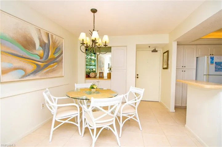 Dining room featuring a textured ceiling, a notable chandelier, and light tile patterned flooring
