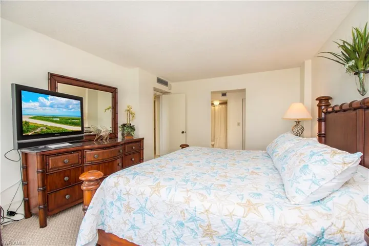 Bedroom with a textured ceiling and light colored carpet