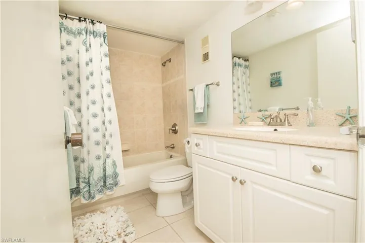 Full bathroom with vanity, tile patterned flooring, toilet, and shower / tub combo