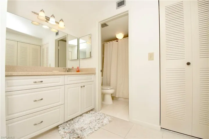 Bathroom featuring vanity, tile patterned floors, and toilet