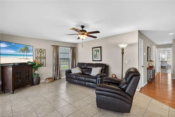 Living room featuring light tile patterned floors and ceiling fan