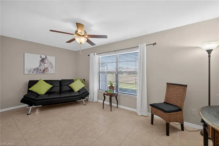 Sitting room featuring light tile patterned flooring and ceiling fan