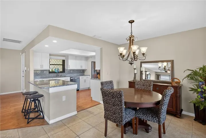 Dining space with light tile patterned floors, a chandelier, and recessed lighting
