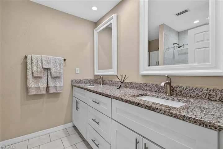 Full bathroom with double vanity and a tile shower