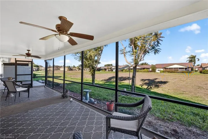 Sunroom / solarium with ceiling fan and a residential view