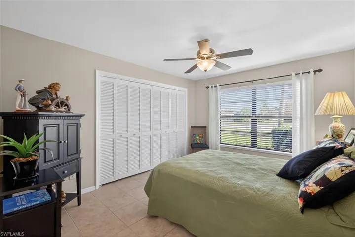 Bedroom featuring light tile patterned floors, a closet, and ceiling fan