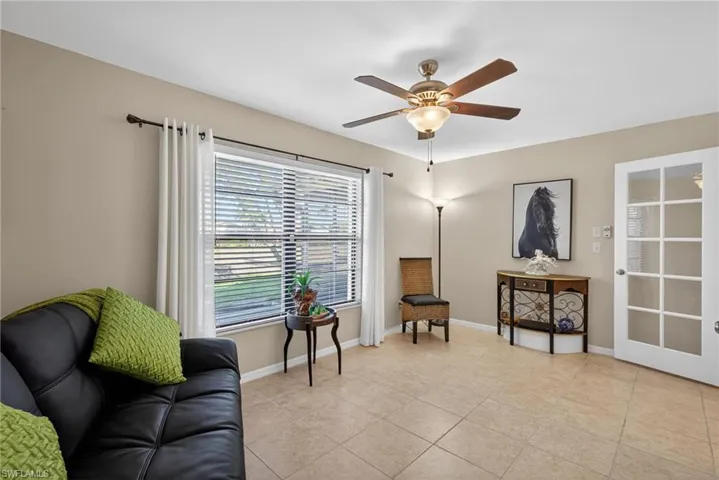 Sitting room with light tile patterned flooring and a ceiling fan