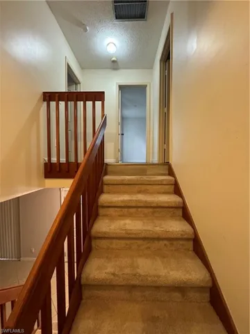 Staircase with a textured ceiling