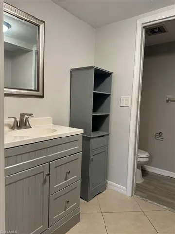 Bathroom featuring vanity, tile patterned flooring, and toilet