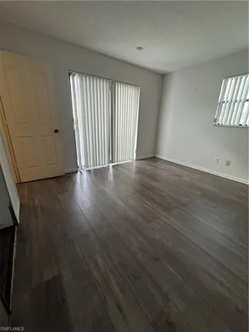 Empty room featuring a textured ceiling and dark wood-type flooring