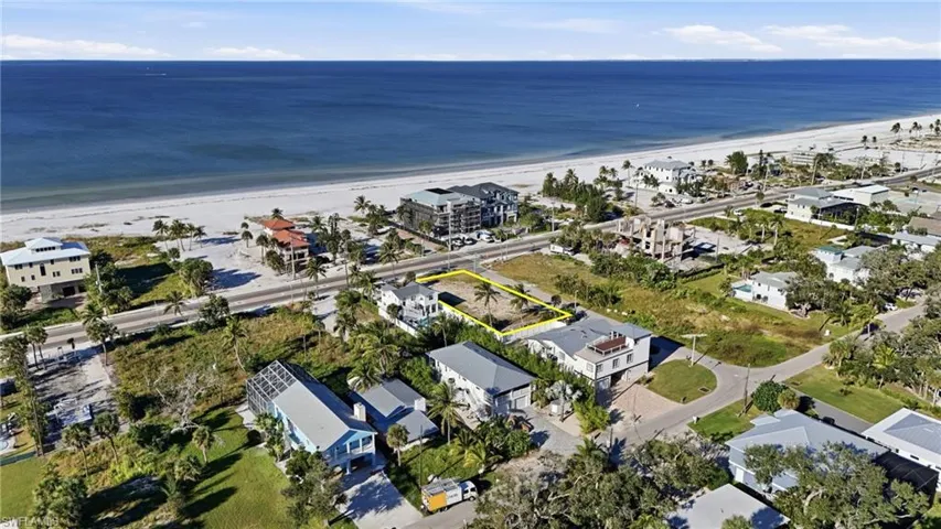Aerial overview of property's location featuring expansive beach - Virtually Edited Image