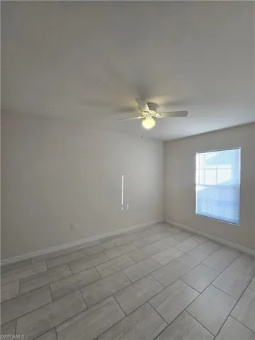 Spare room with baseboards and a ceiling fan