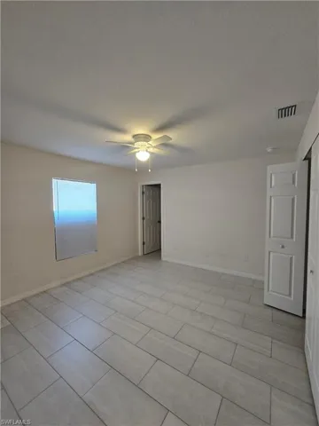 Empty room with a ceiling fan and baseboards