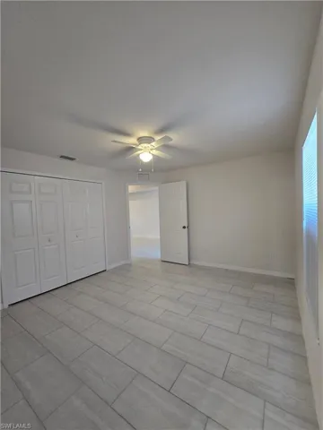 Unfurnished bedroom featuring ceiling fan and a closet