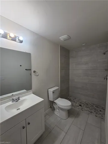 Full bathroom with a tile shower and vanity